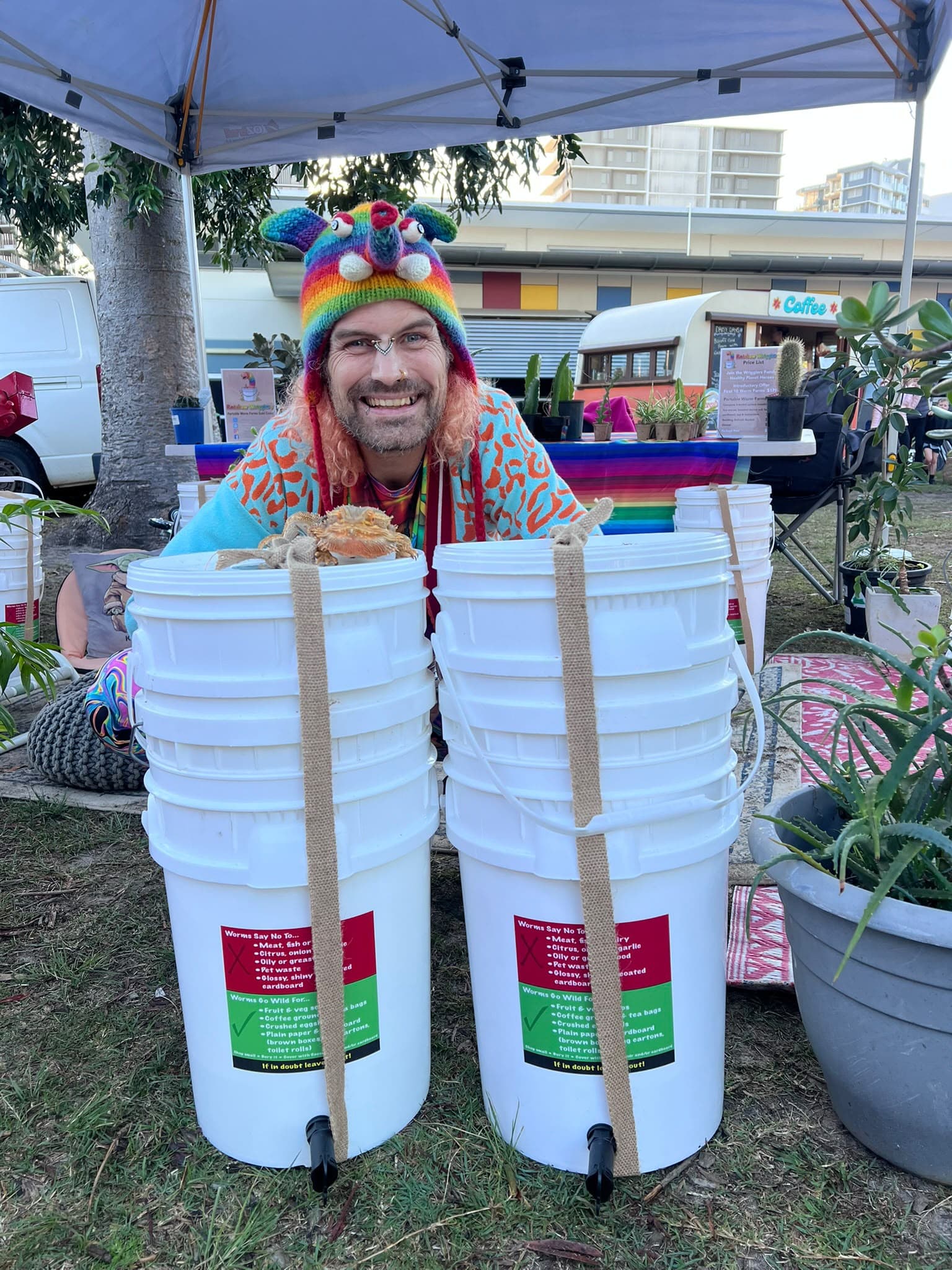 Rainbow smiling behind two ready-to-go Rainbow Wrigglers worm farms